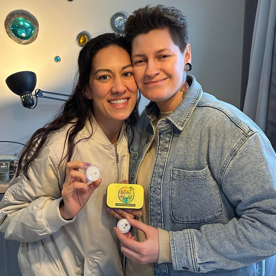 Two sapphire mining guests pose smiling in Glitter and Gold Studio, showing off their raw Montana sapphires and a jewelry emergency kit. 